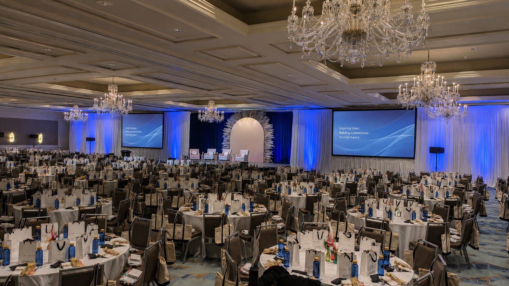 Corporate AV production setup with LED walls and stage lighting at a conference general session